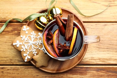 Photo of Tasty mulled wine with spices, cookies and Christmas decor on wooden table, top view