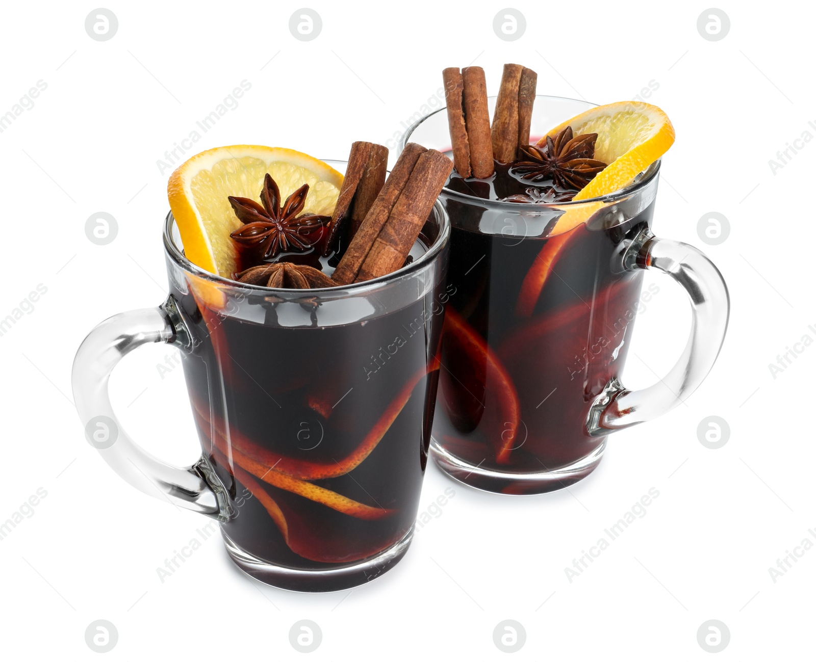 Photo of Tasty mulled wine with spices and orange slices in cups isolated on white. Christmas drink