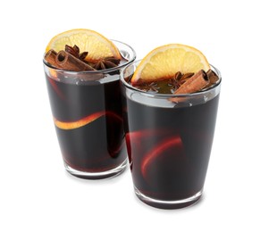 Photo of Tasty mulled wine with spices and orange slices in glasses isolated on white. Christmas drink