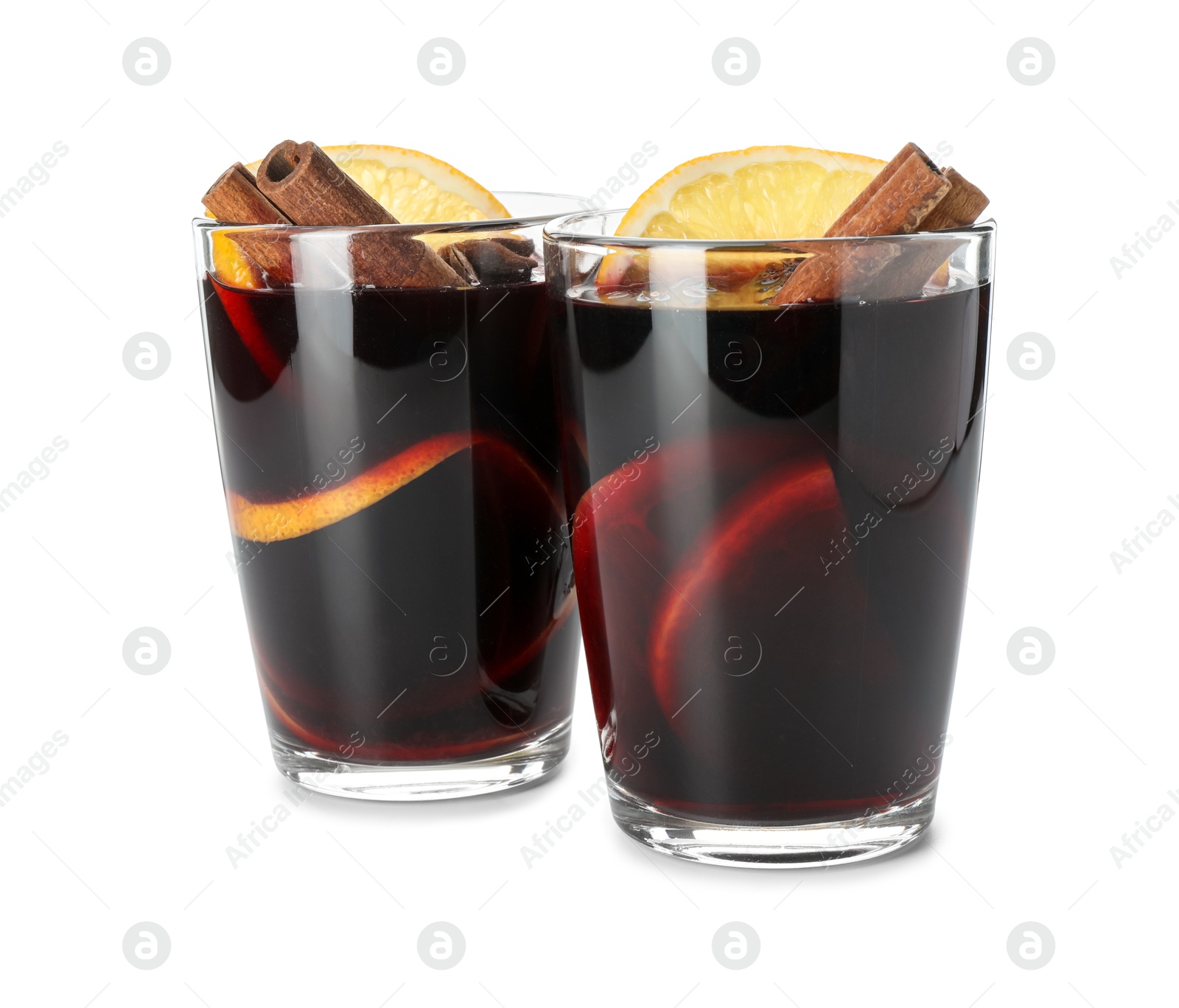 Photo of Tasty mulled wine with spices and orange slices in glasses isolated on white. Christmas drink