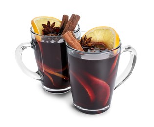 Photo of Tasty mulled wine with spices and orange slices in cups isolated on white. Christmas drink