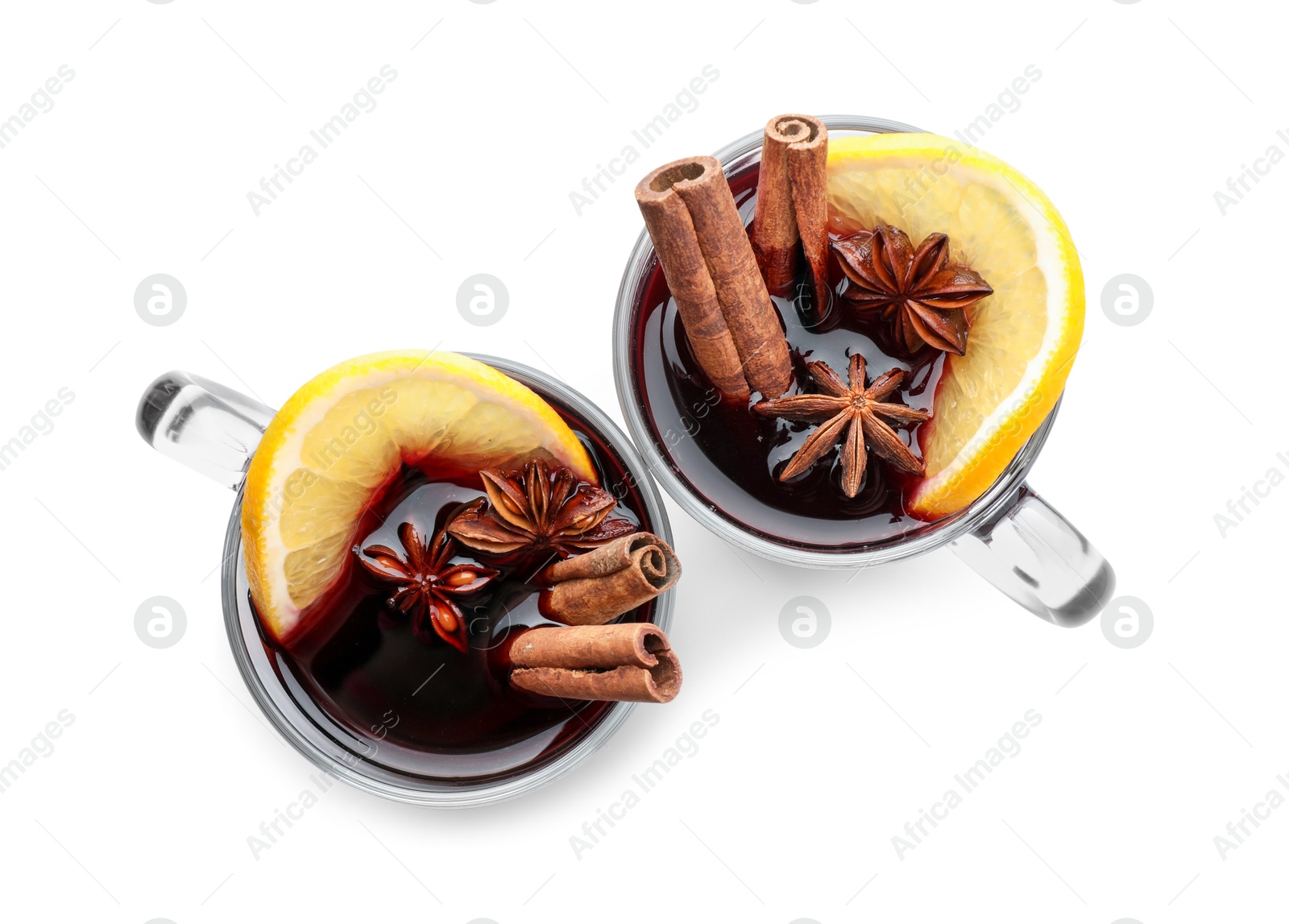 Photo of Tasty mulled wine with spices and orange slice in cups on white background, top view. Christmas drink