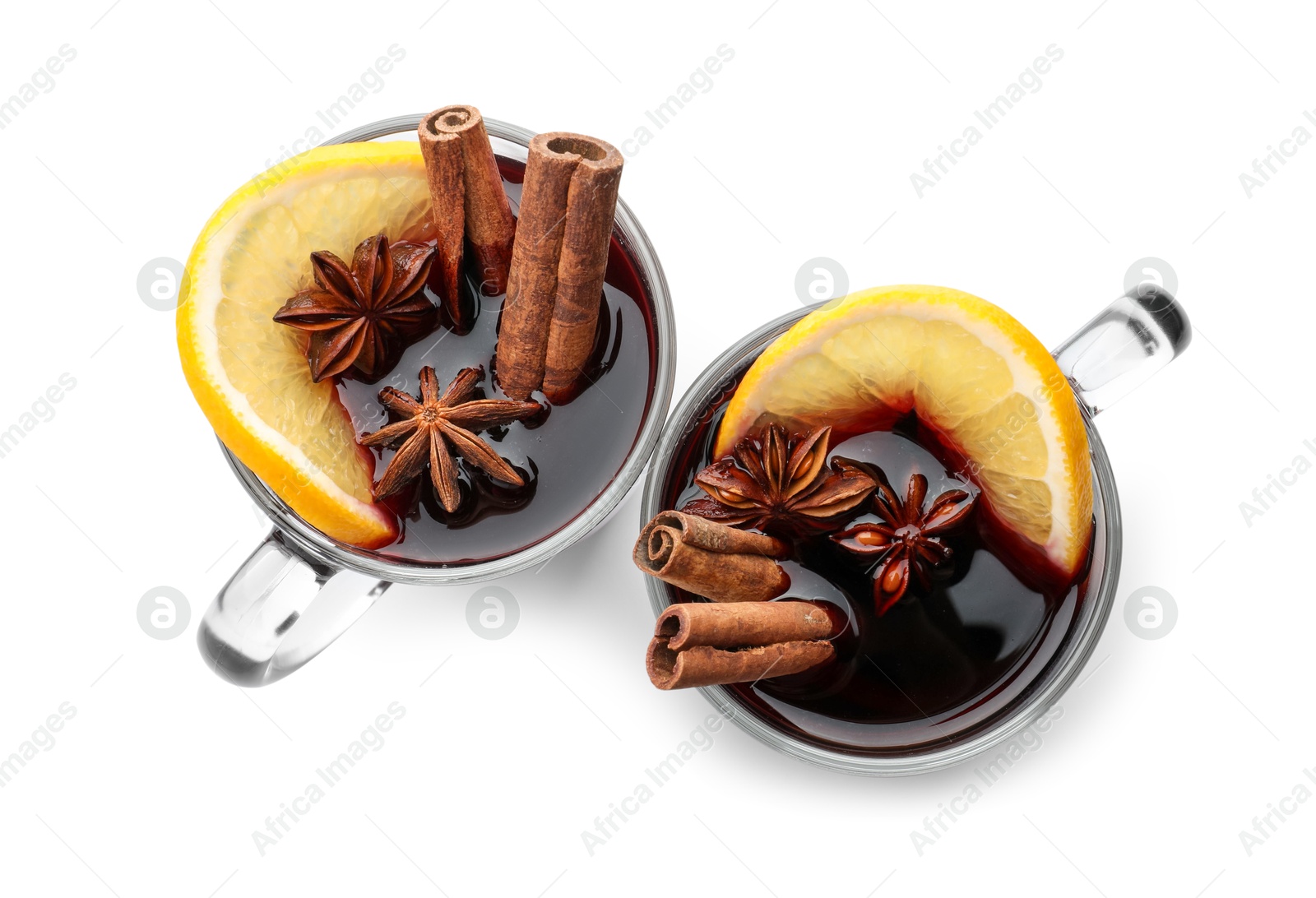 Photo of Tasty mulled wine with spices and orange slice in cups on white background, top view. Christmas drink