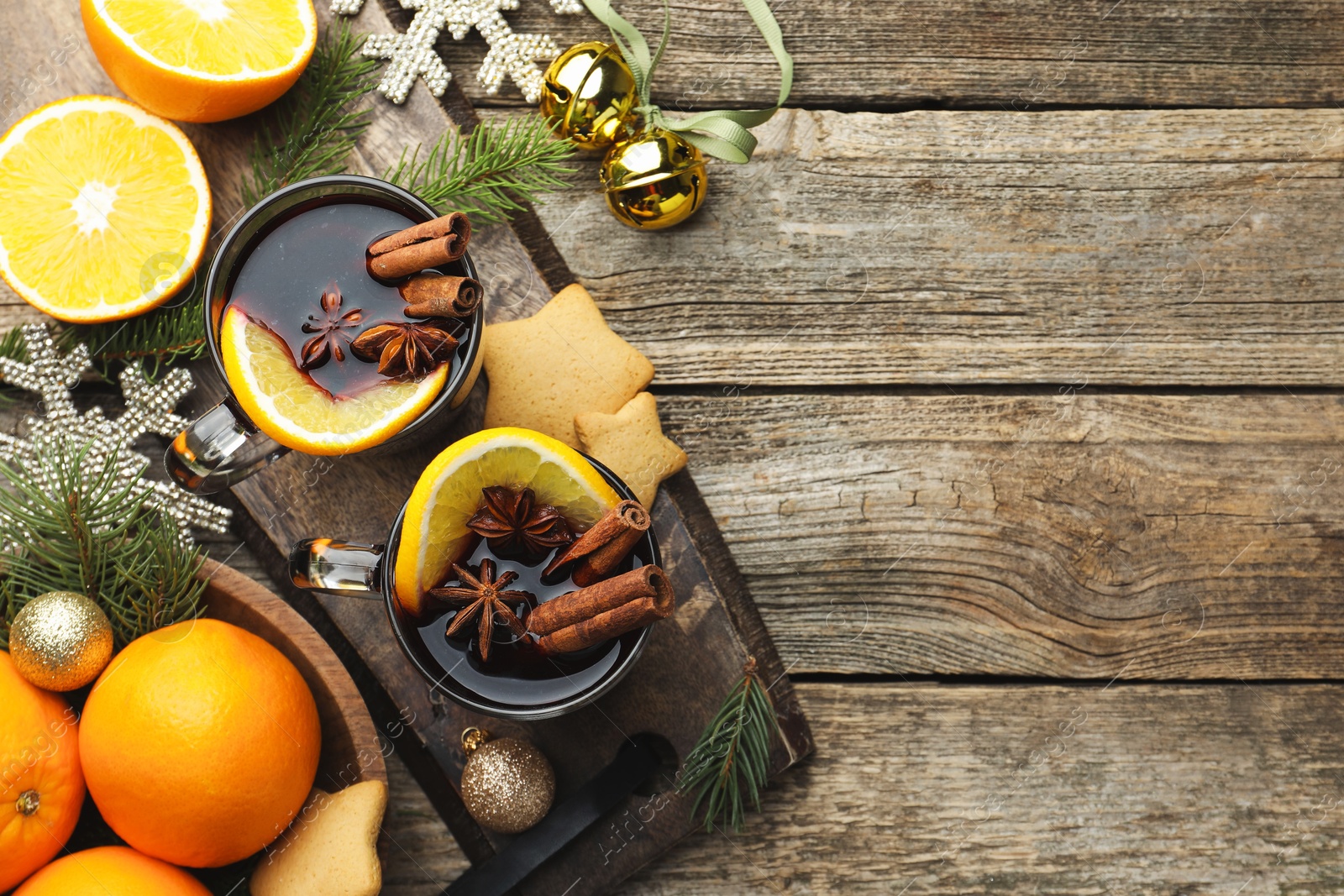 Photo of Tasty mulled wine with spices, orange, cookies and Christmas decor on wooden table, flat lay. Space for text