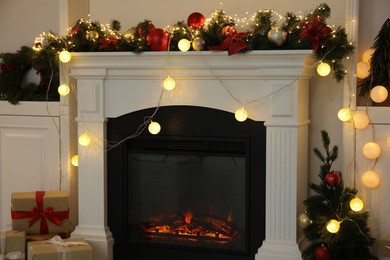 Photo of Stylish fireplace with Christmas decor and presents in cozy room