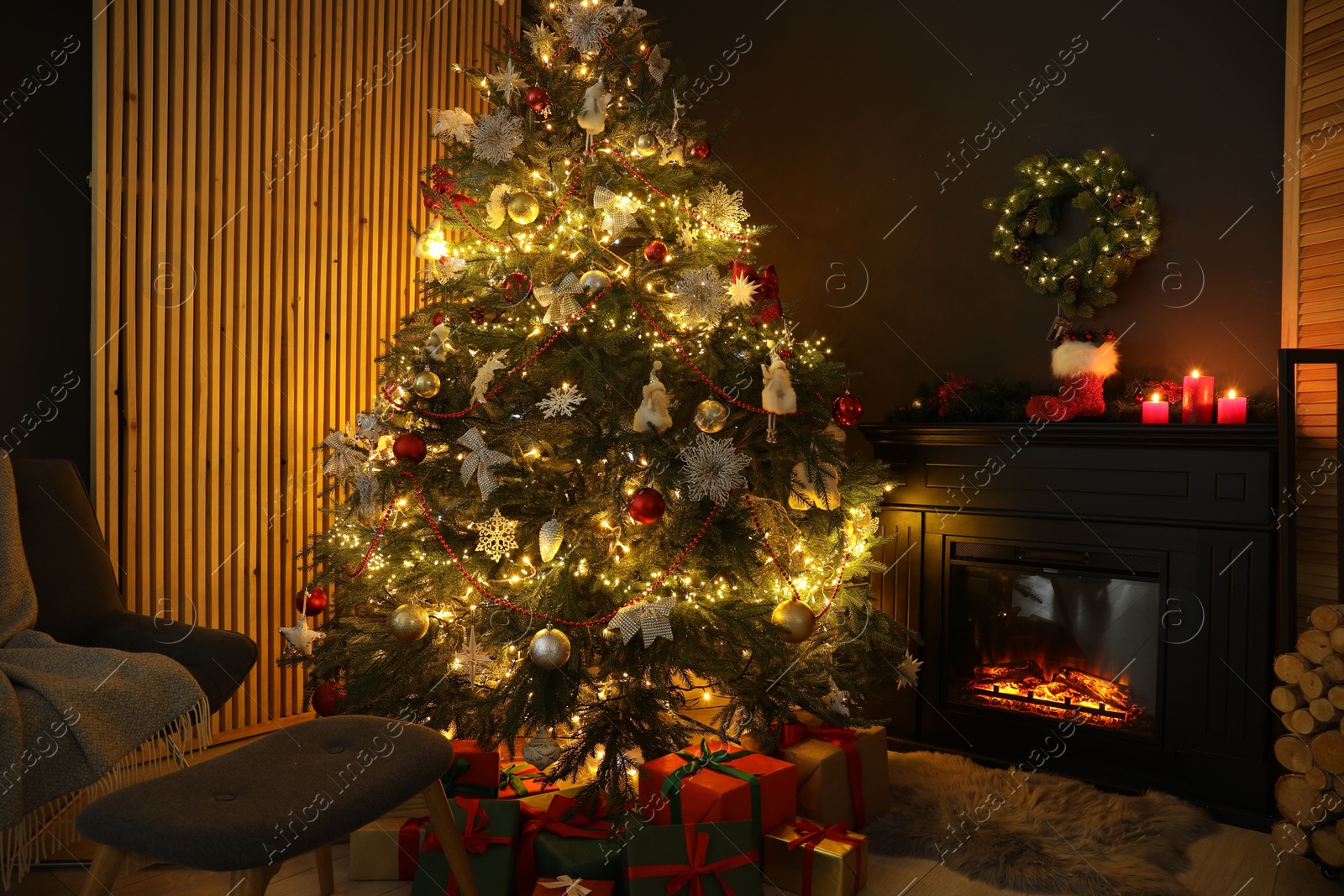 Photo of Christmas tree with festive decor, presents and fireplace in cozy room