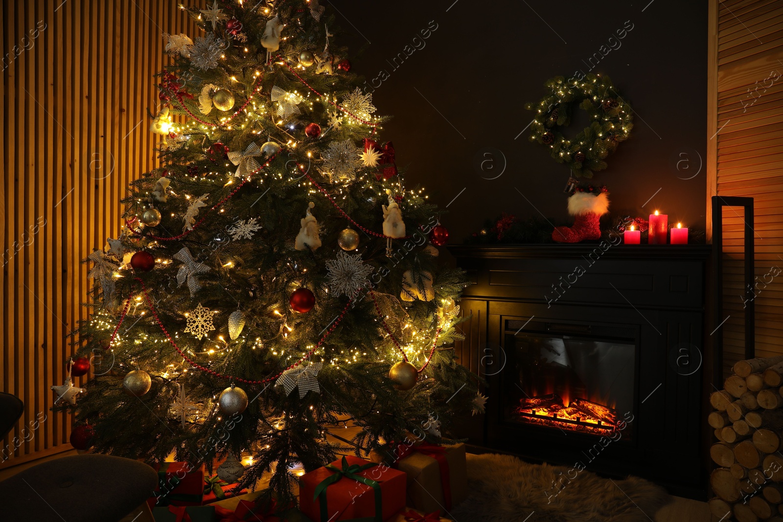 Photo of Christmas tree with festive decor, presents and fireplace in cozy room