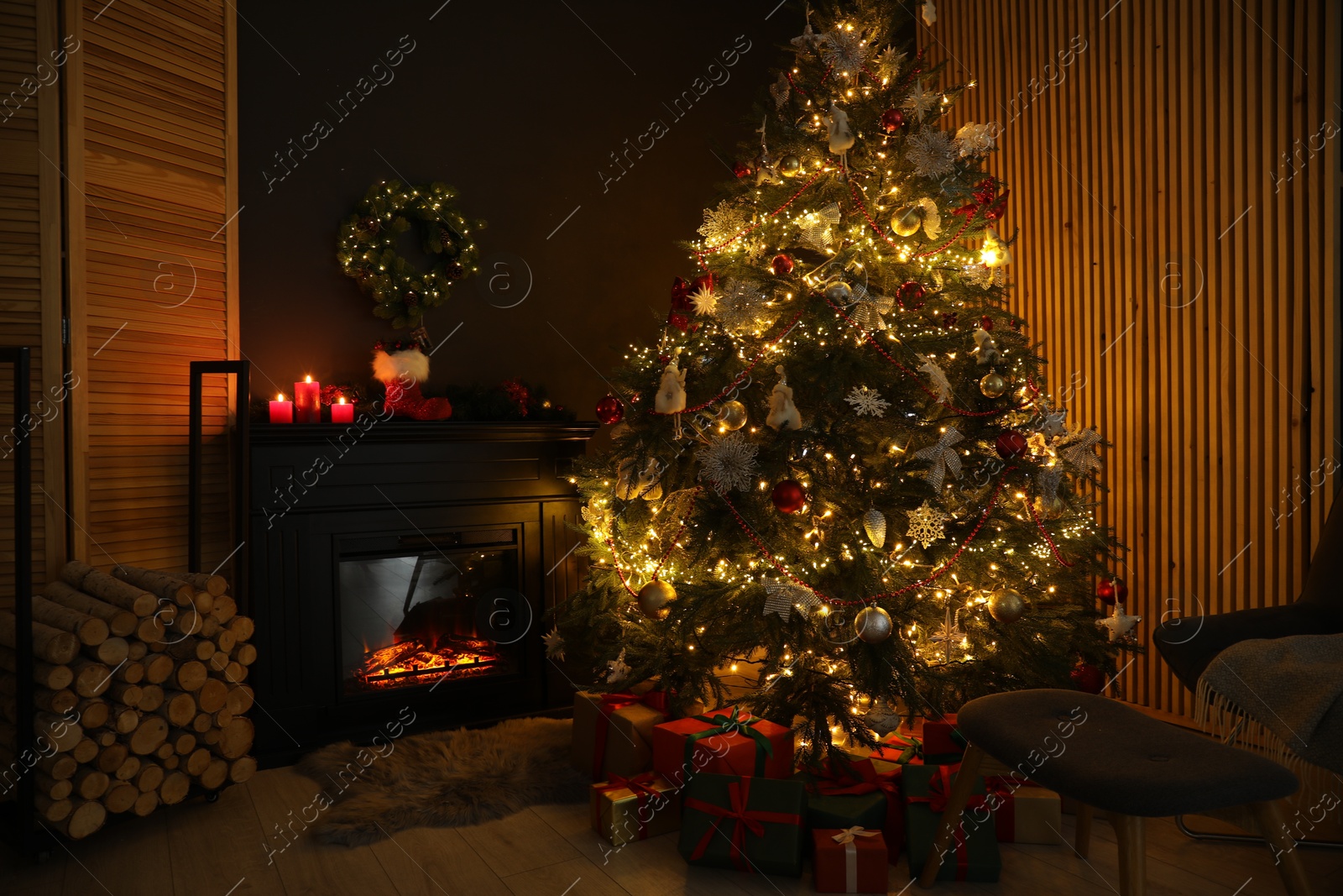 Photo of Stylish fireplace, Christmas tree with festive decor and presents indoors