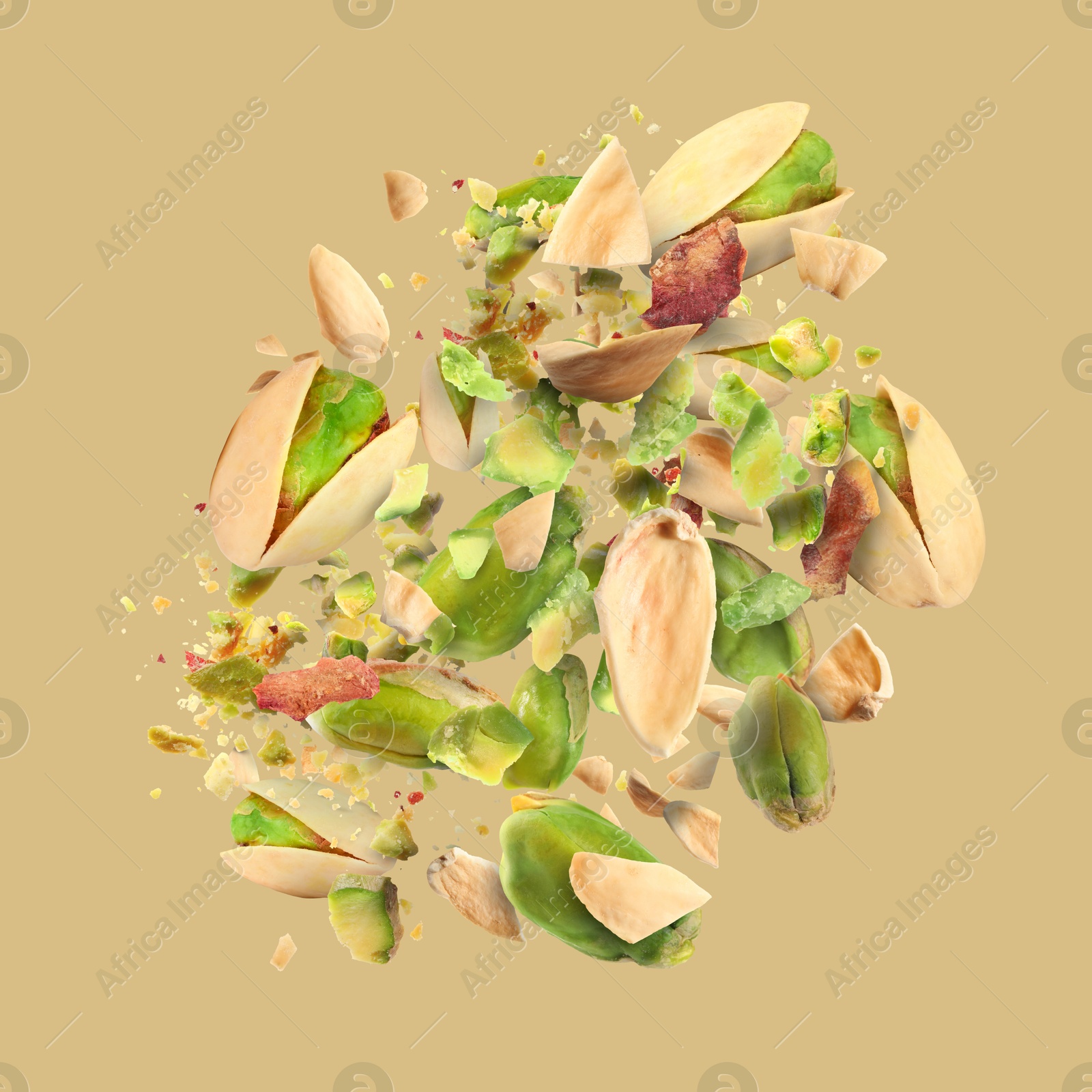 Image of Tasty pistachios with cracked nutshell in air on dark beige background