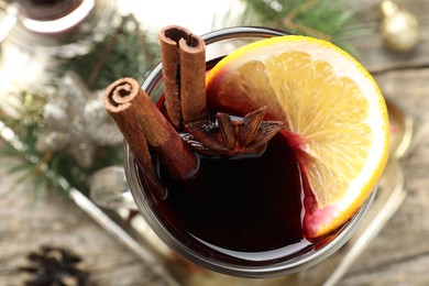 Photo of Tasty mulled wine with spices and Christmas decor on table, top view