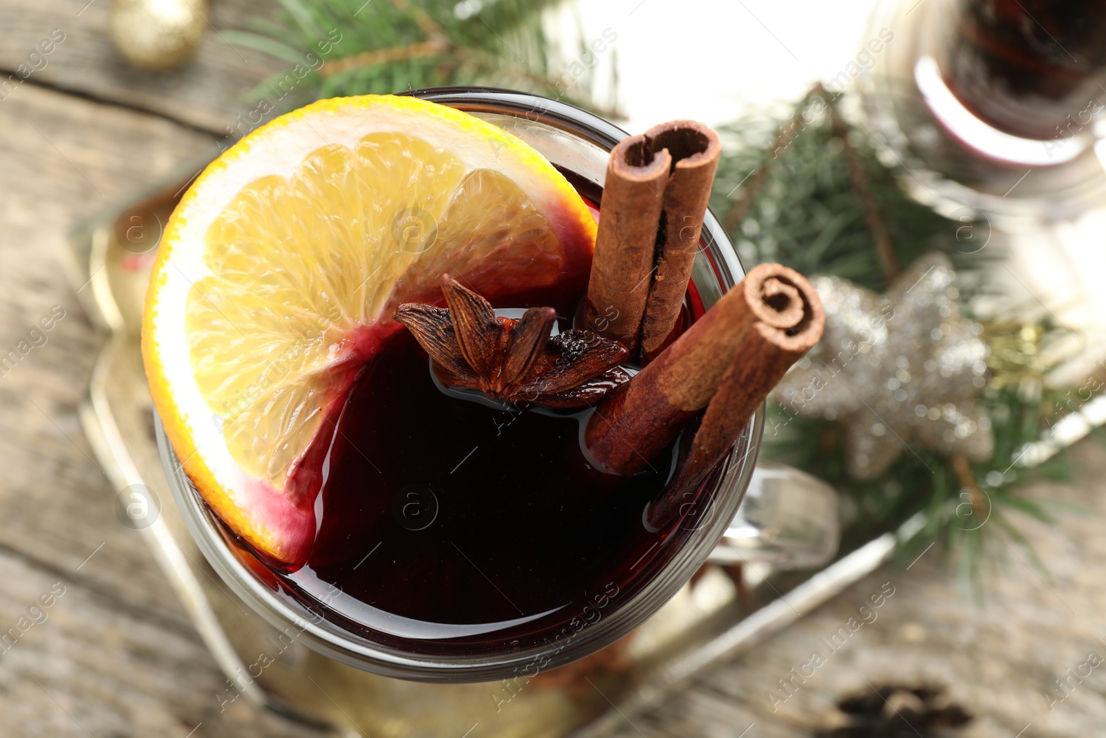 Photo of Tasty mulled wine with spices and Christmas decor on table, top view