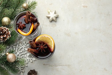 Photo of Tasty mulled wine with spices and Christmas decor on light grey table, flat lay. Space for text