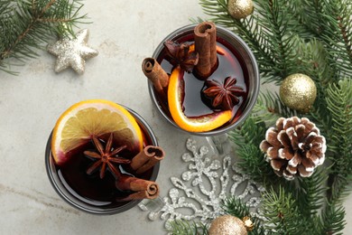 Photo of Tasty mulled wine with spices and Christmas decor on light grey table, flat lay