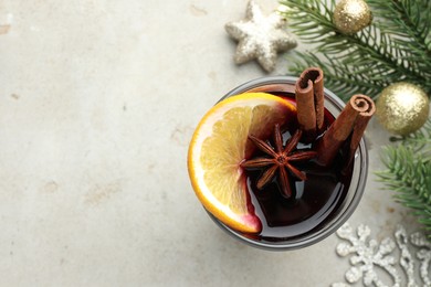 Photo of Tasty mulled wine with spices and Christmas decor on light grey table, flat lay