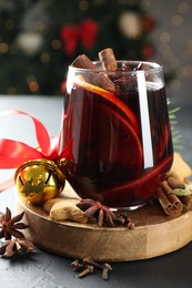 Photo of Tasty mulled wine with spices, cookies and Christmas decor on black table, closeup