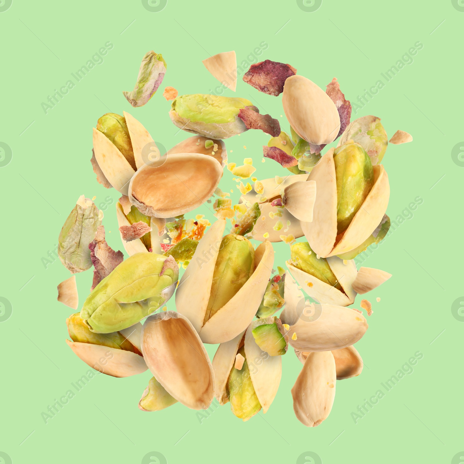 Image of Tasty pistachios with cracked nutshell in air on color background