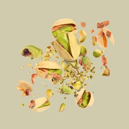 Image of Tasty pistachios with cracked nutshell in air on light grey background