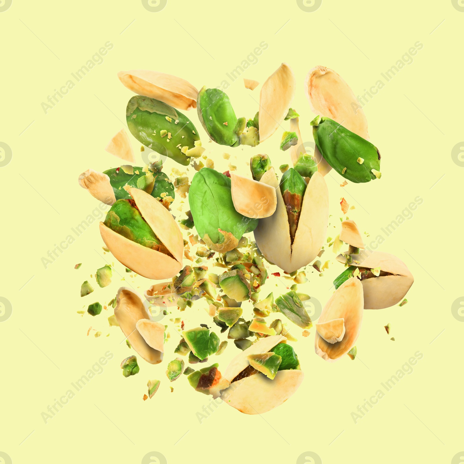 Image of Tasty pistachios with cracked nutshell in air on color background