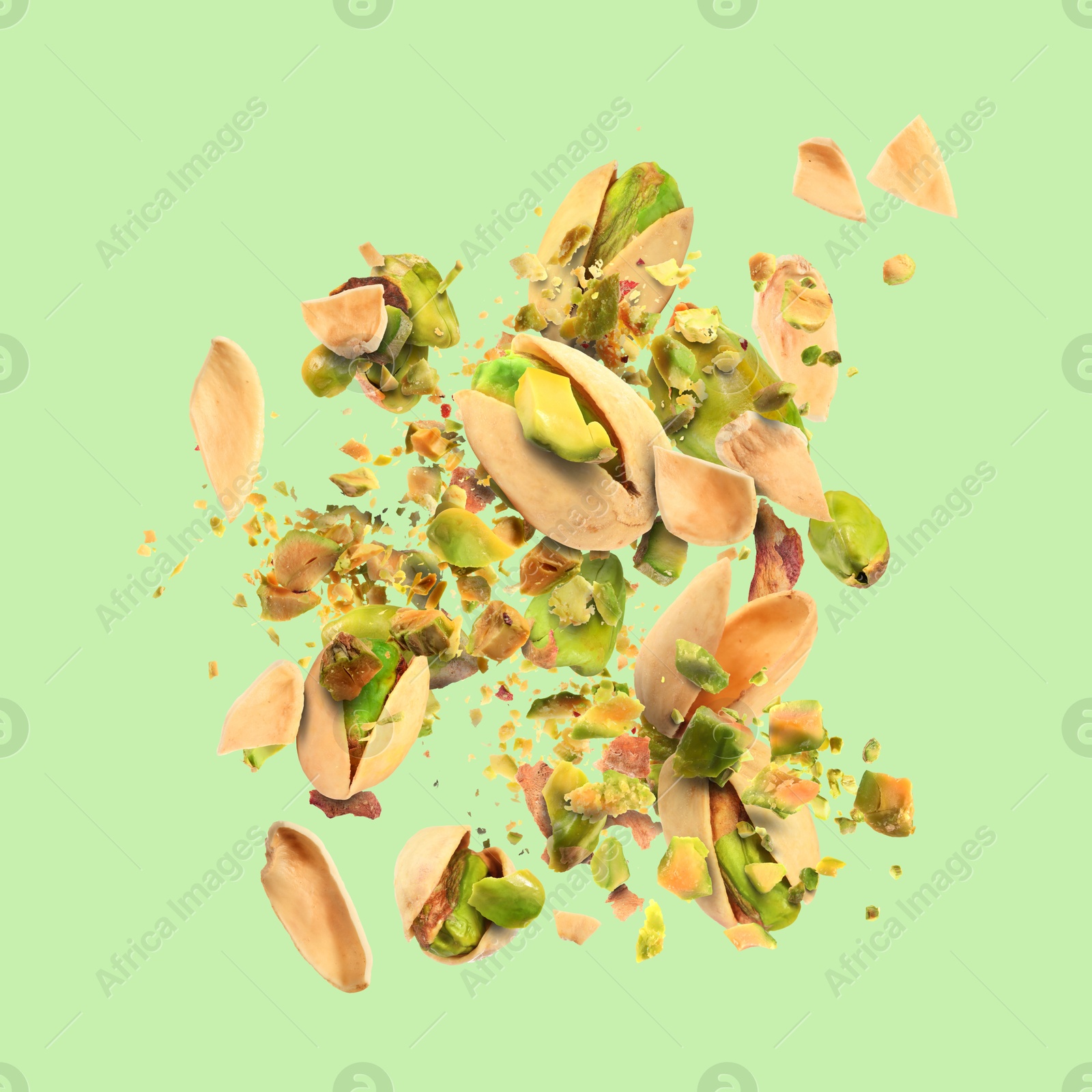 Image of Tasty pistachios with cracked nutshell in air on color background