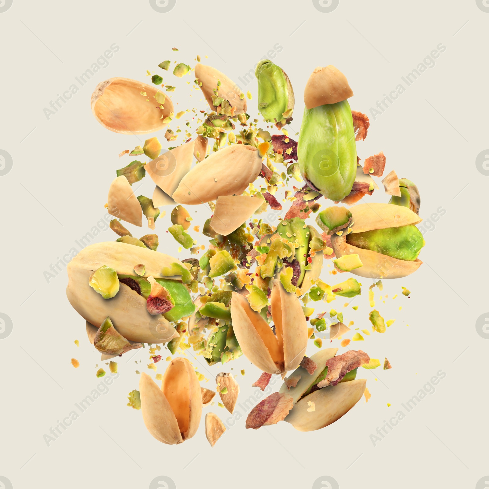 Image of Tasty pistachios with cracked nutshell in air on light grey background