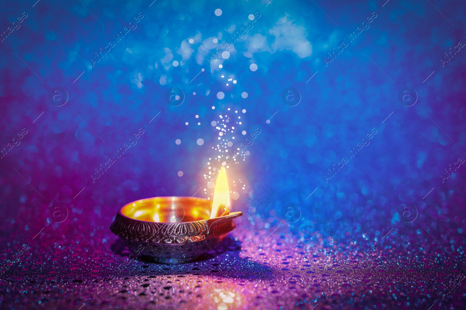 Image of Happy Diwali celebration. Diya lamp burning on color background. Space for text. Bokeh effect