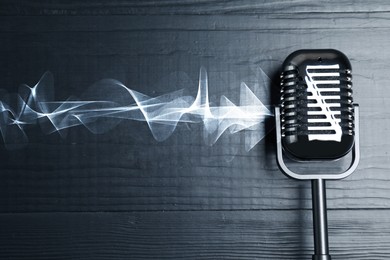 Image of Sound wave and microphone on black wooden background, top view