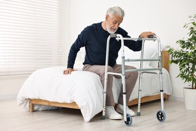 Photo of Senior man with walking frame on bed in hospital ward