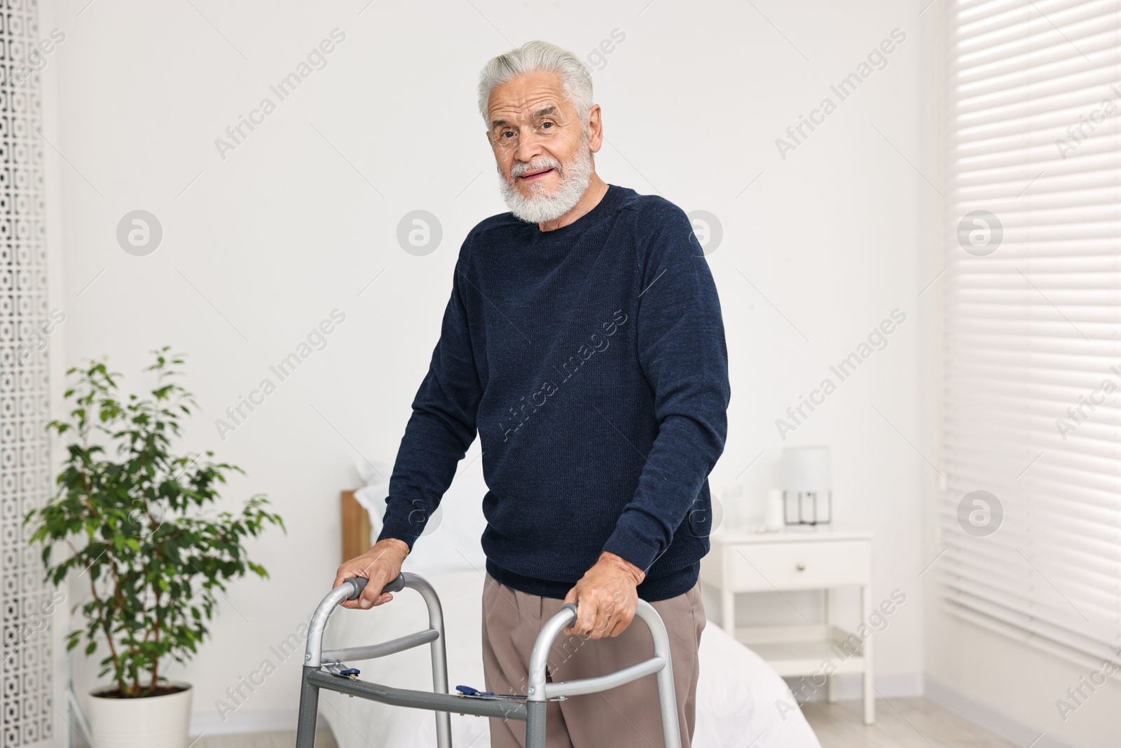 Photo of Senior man with walking frame in hospital ward