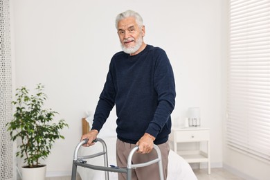 Senior man with walking frame in hospital ward