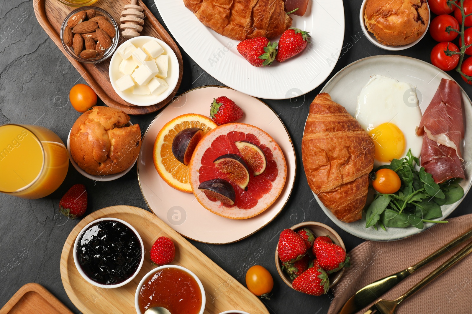 Photo of Different tasty food served for brunch on grey textured table, flat lay