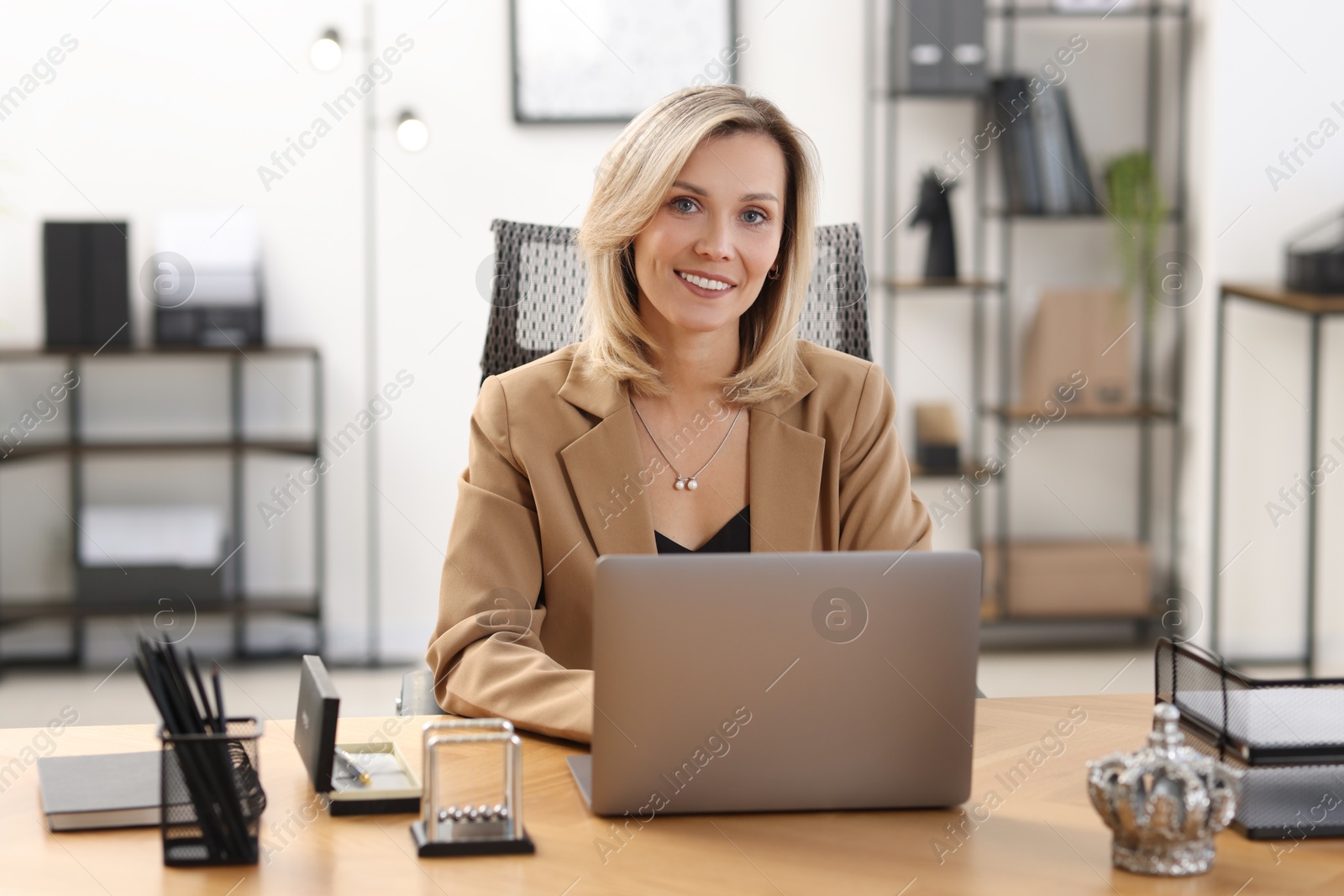 Photo of Businesswoman working on laptop at table in office