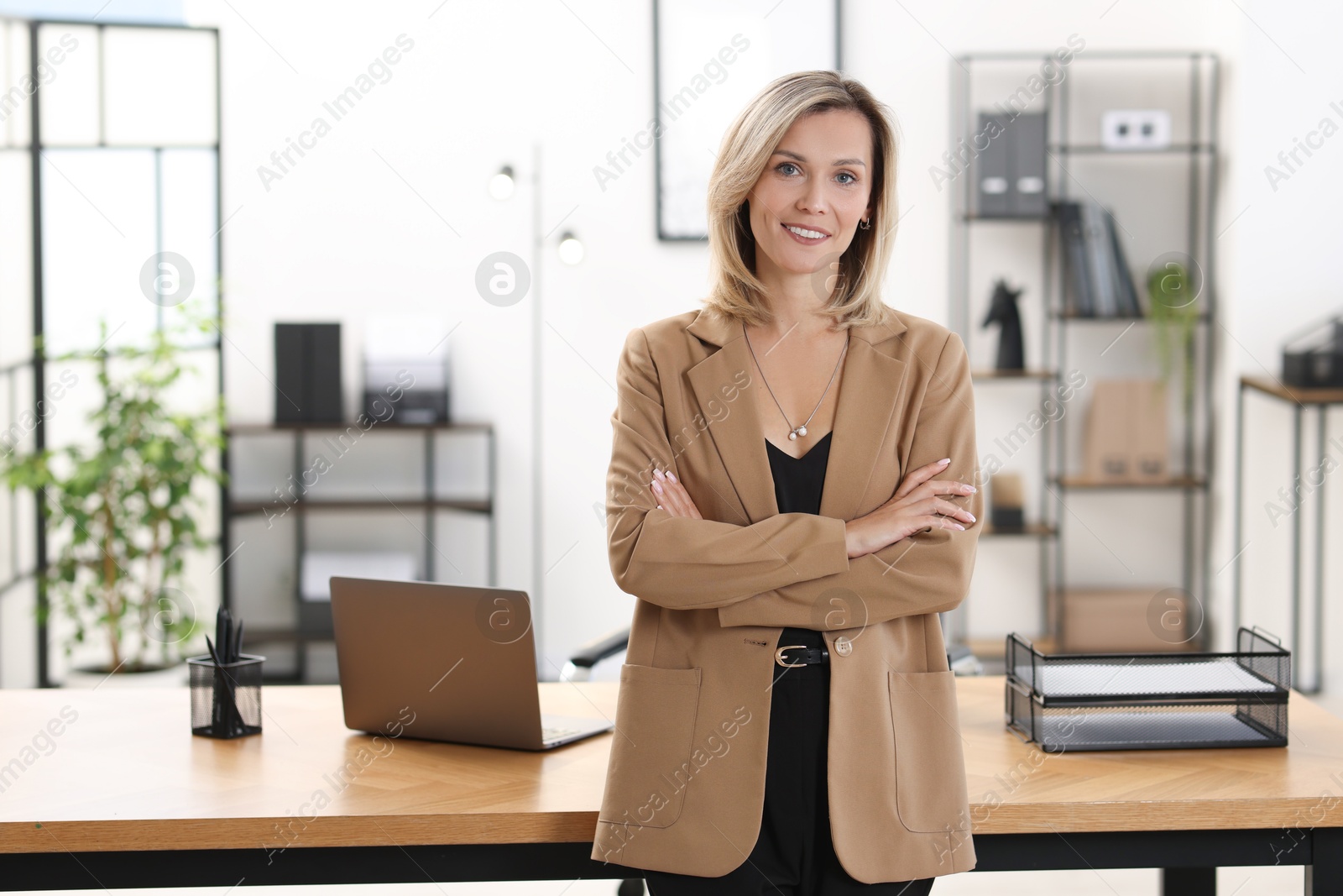 Photo of Portrait of happy businesswoman with crossed arms in office