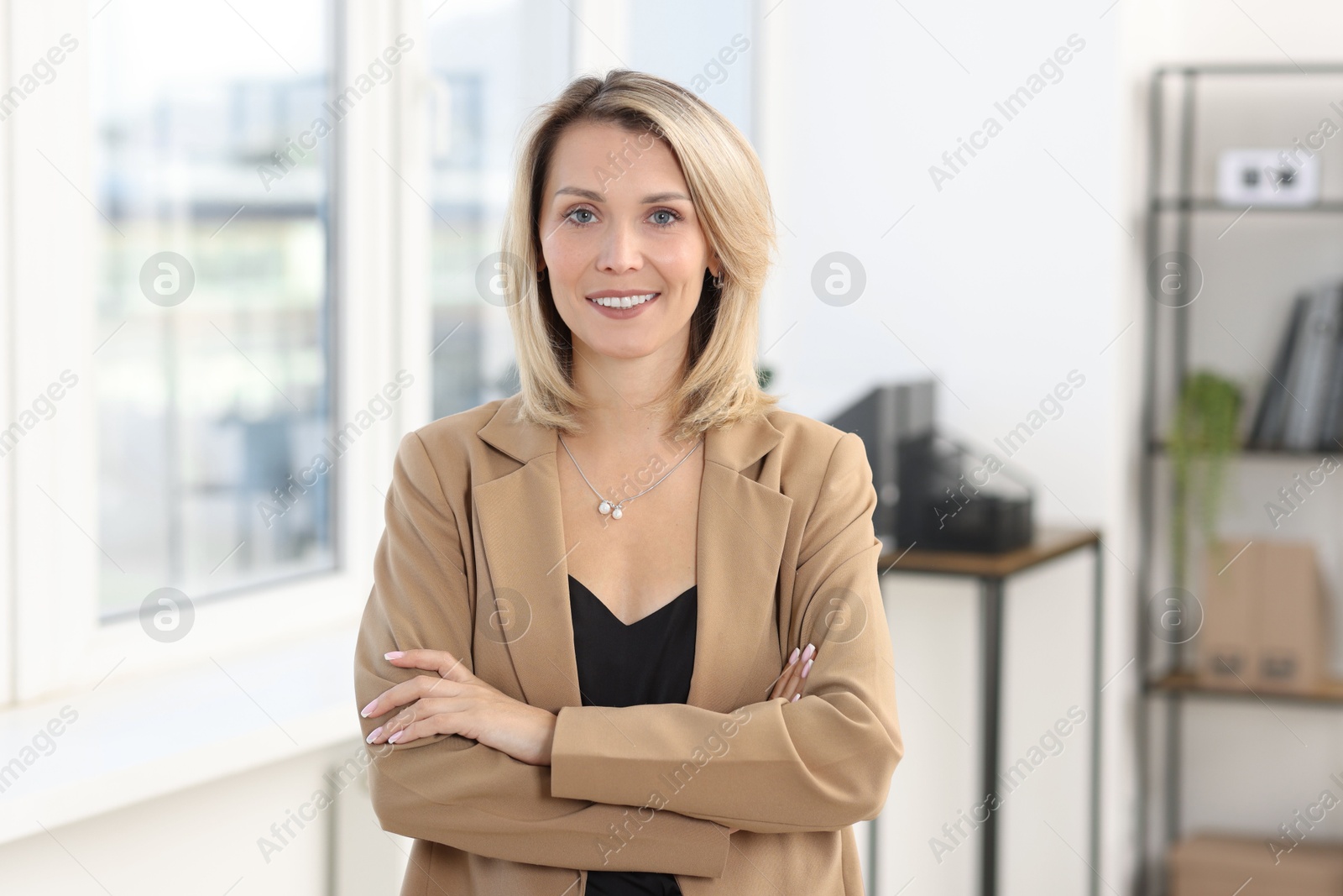 Photo of Portrait of happy businesswoman with crossed arms in office