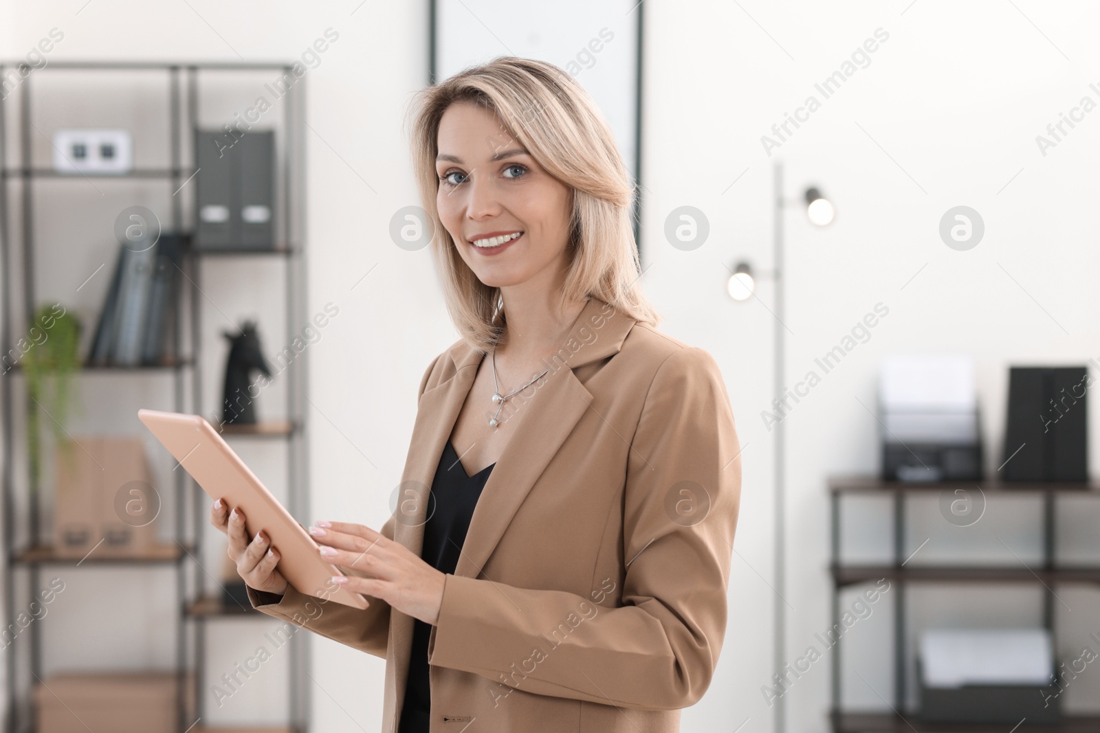 Photo of Portrait of happy businesswoman using tablet in office