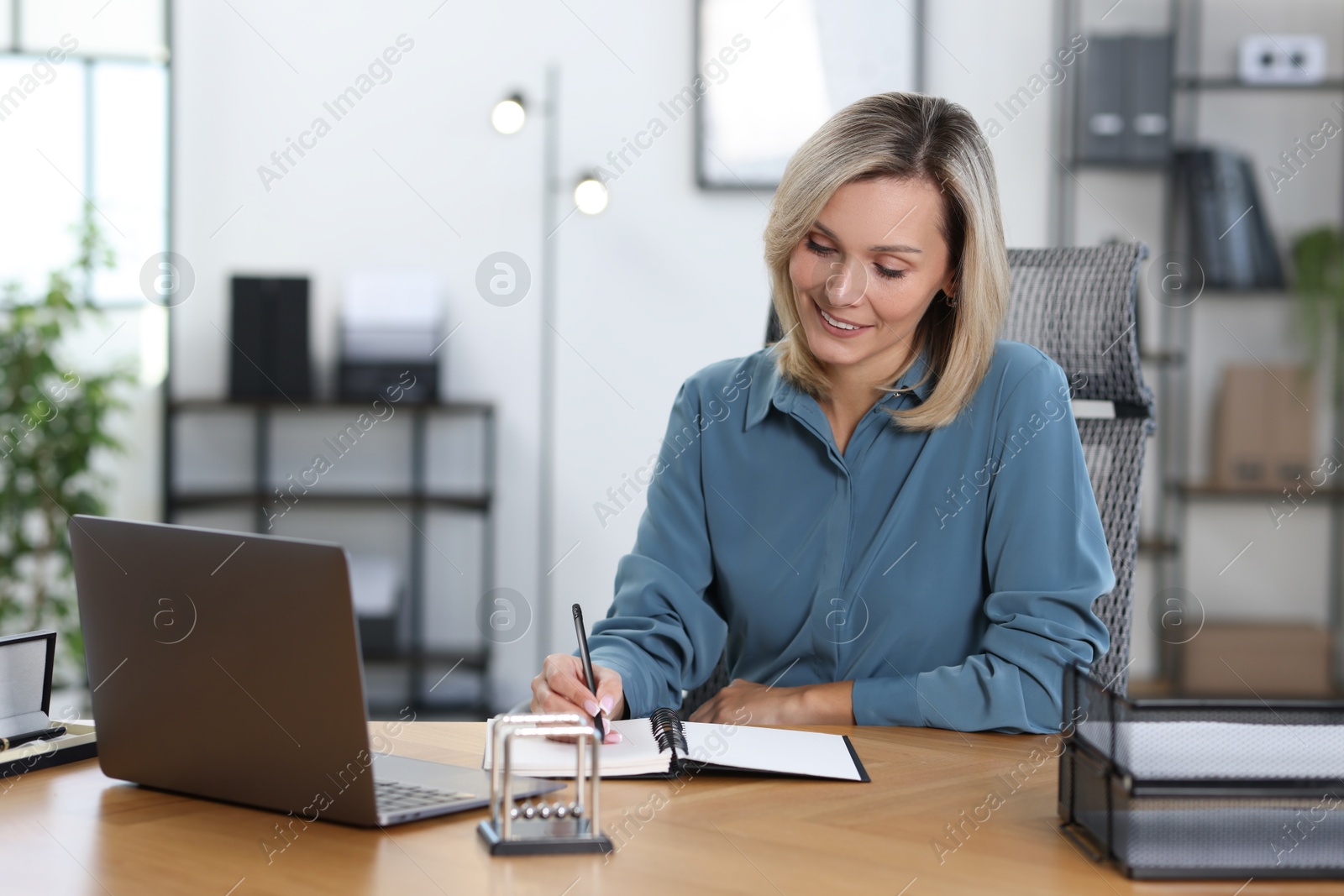 Photo of Happy businesswoman working at table in office