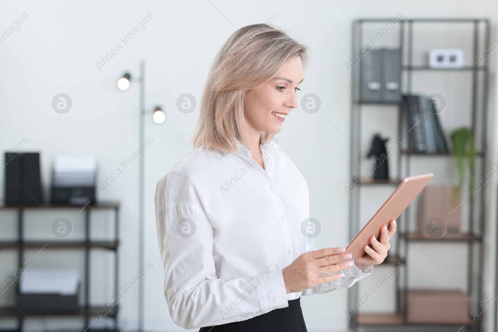 Photo of Portrait of happy businesswoman using tablet in office