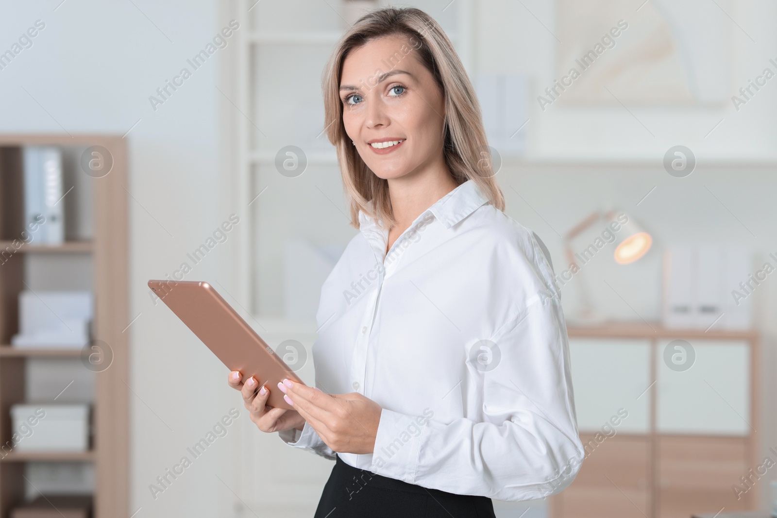 Photo of Portrait of happy businesswoman using tablet in office