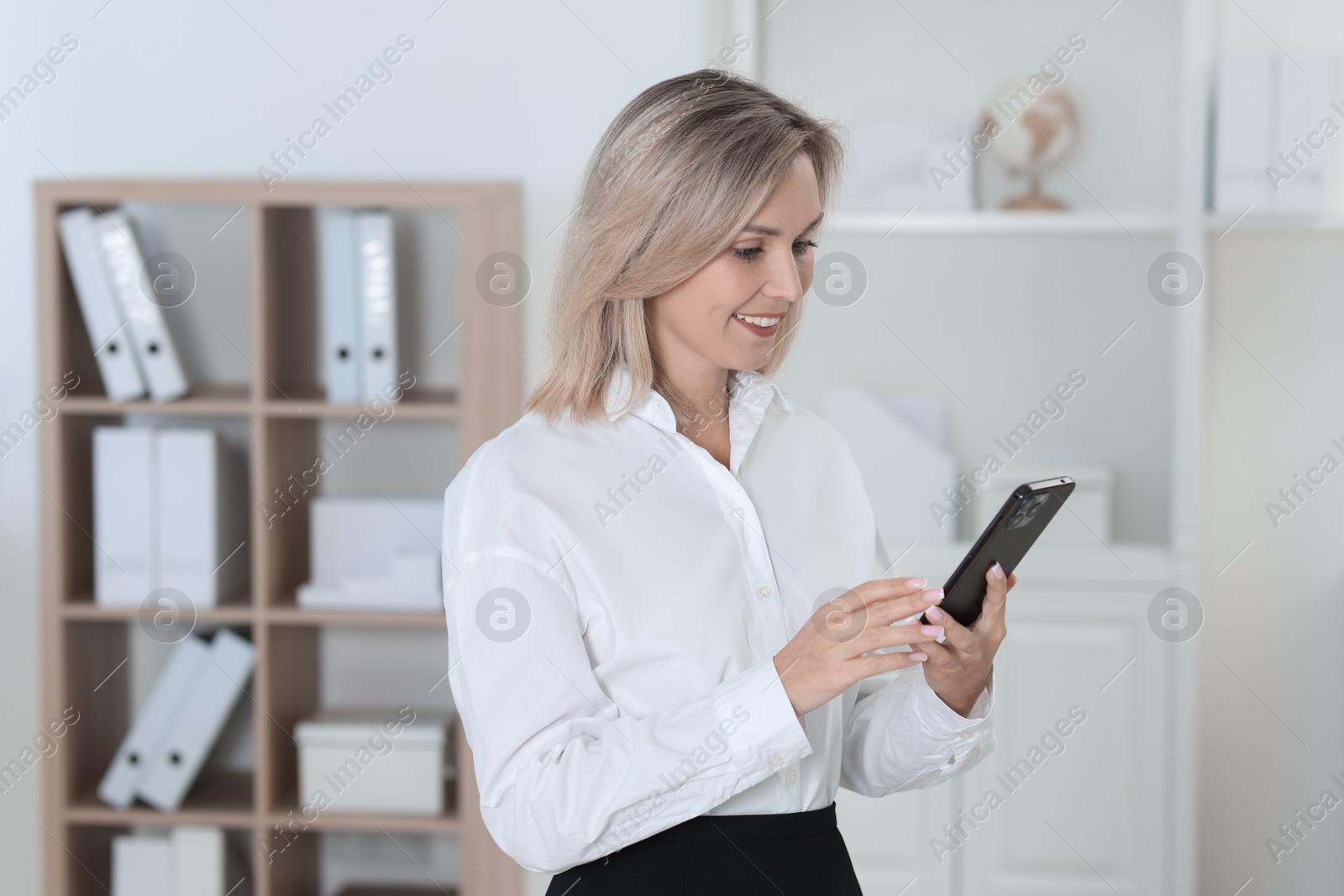 Photo of Portrait of businesswoman using smartphone in office