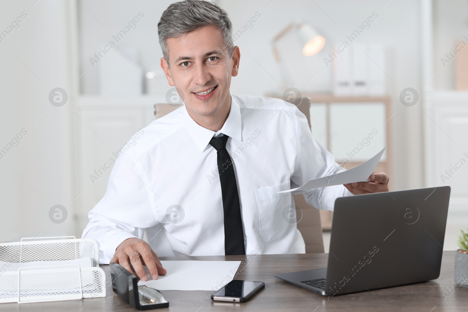 Photo of Businessman working with documents at table in office