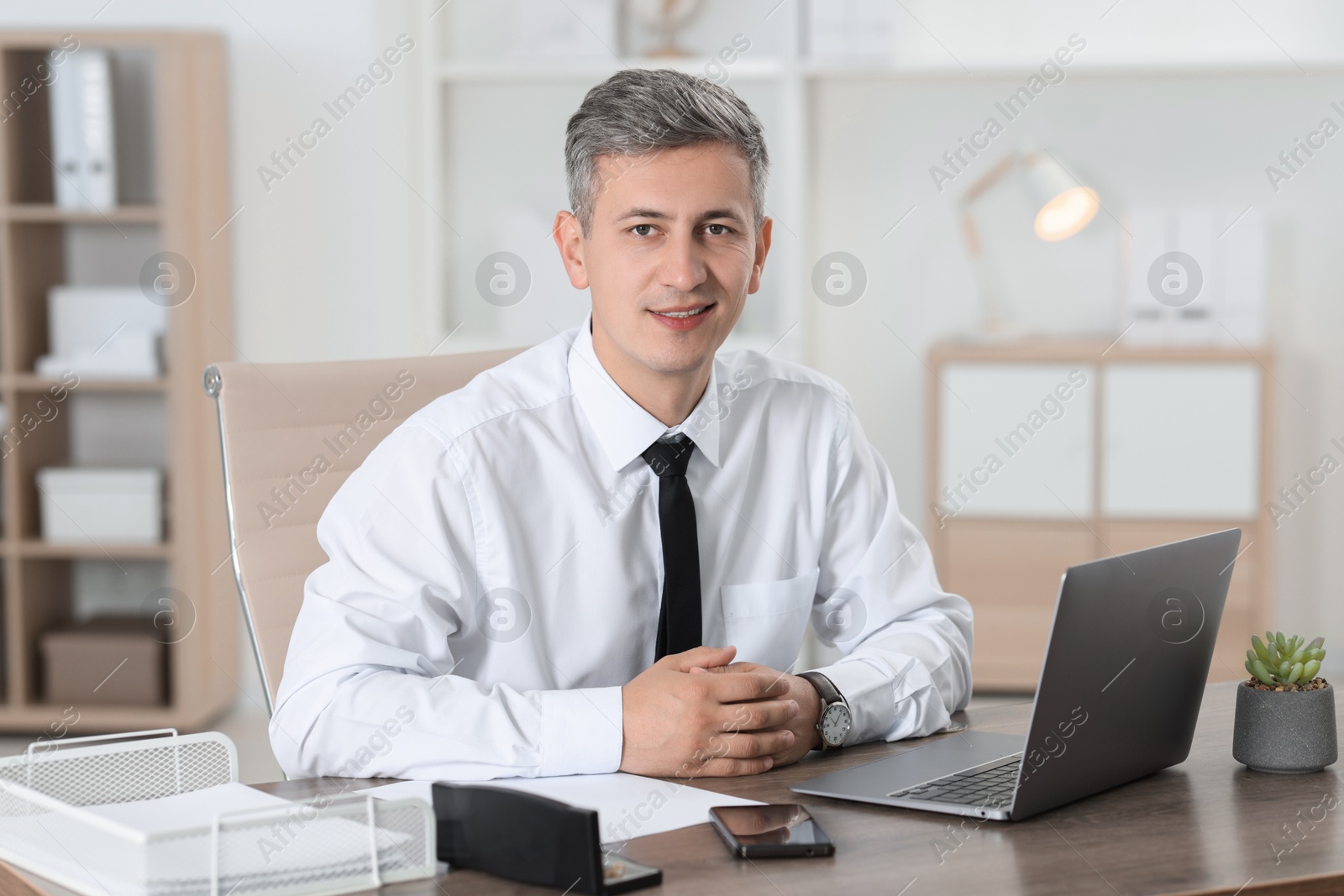 Photo of Portrait of businessman at table in office