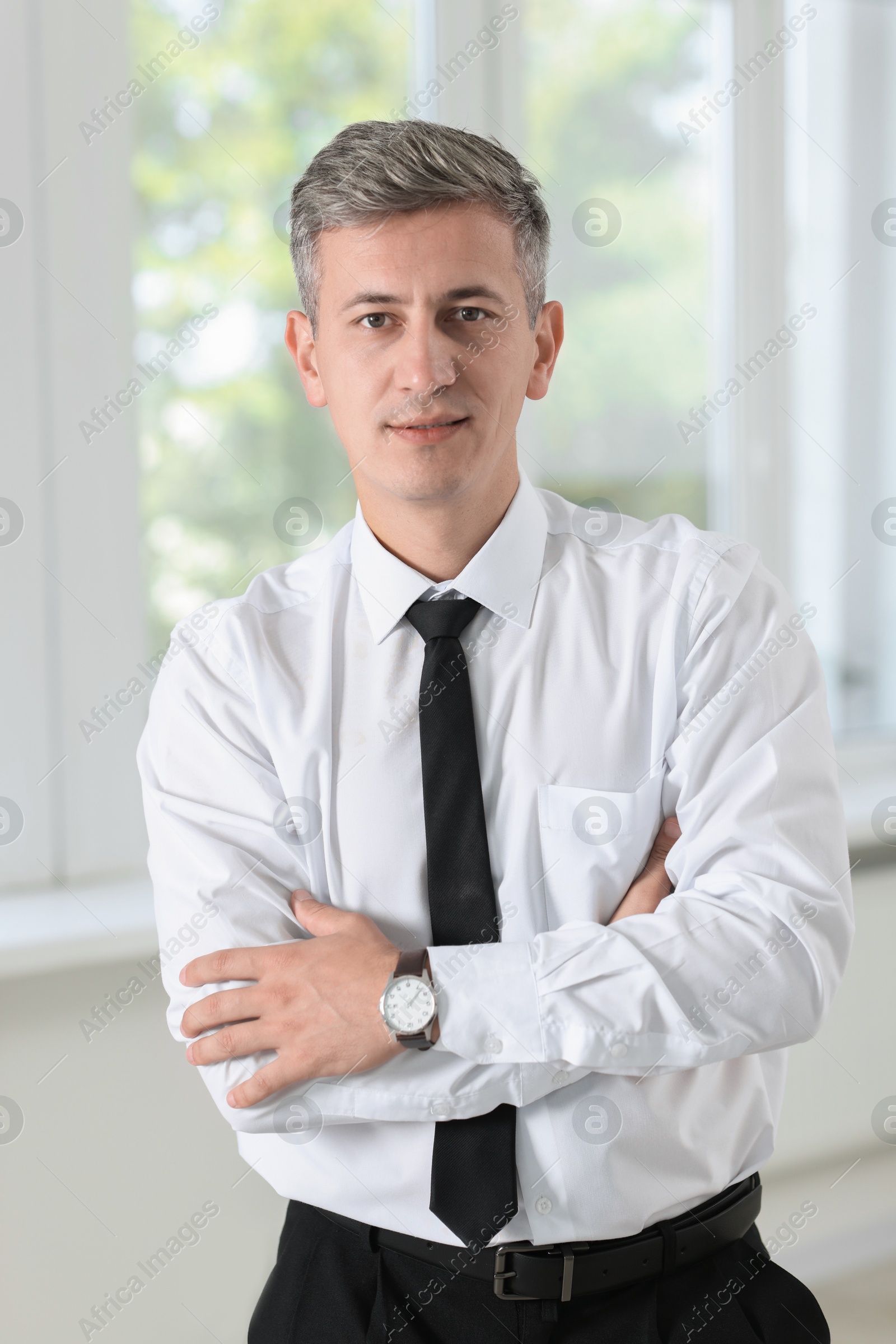 Photo of Portrait of businessman with crossed arms in office