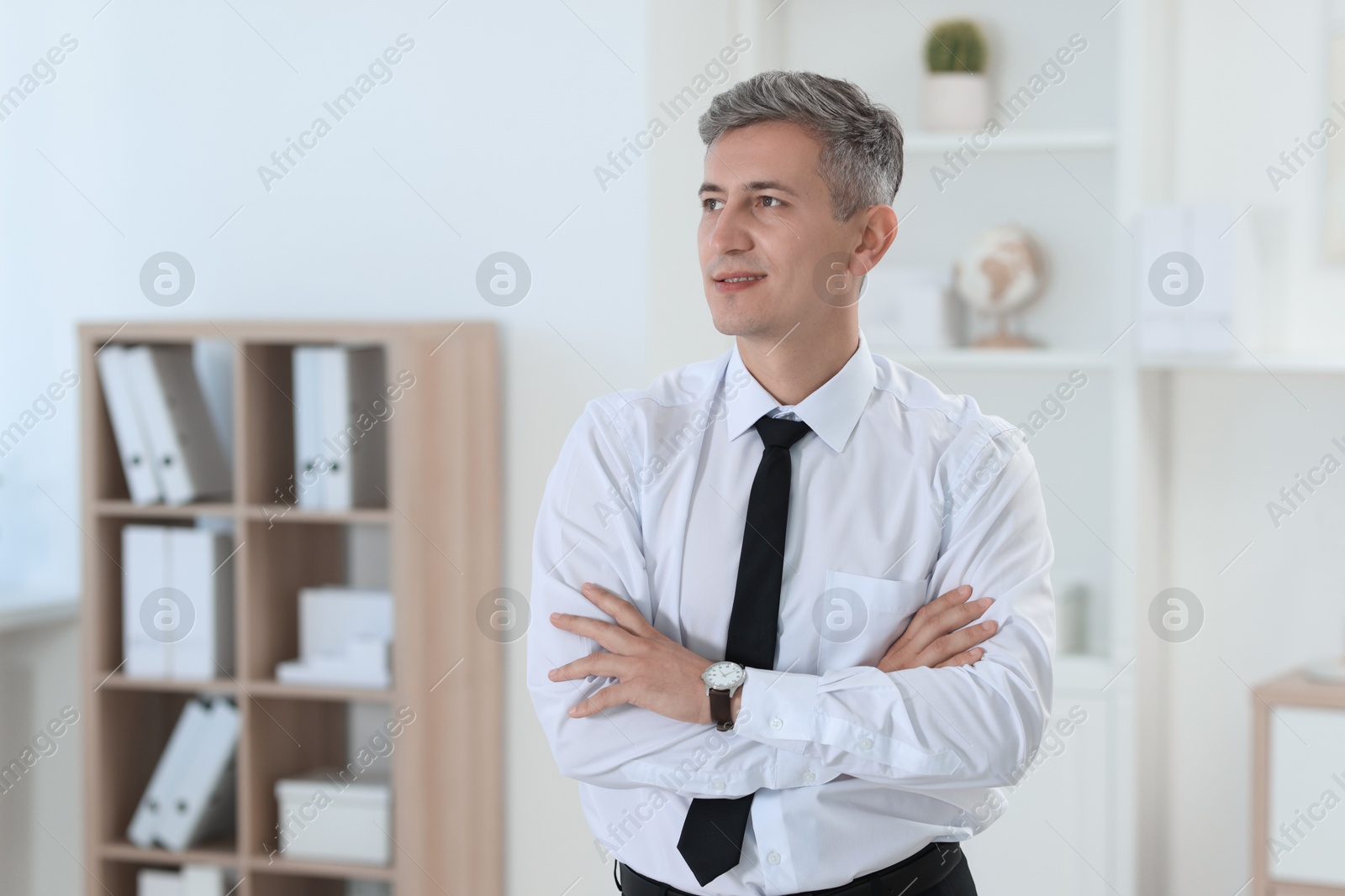 Photo of Portrait of businessman with crossed arms in office