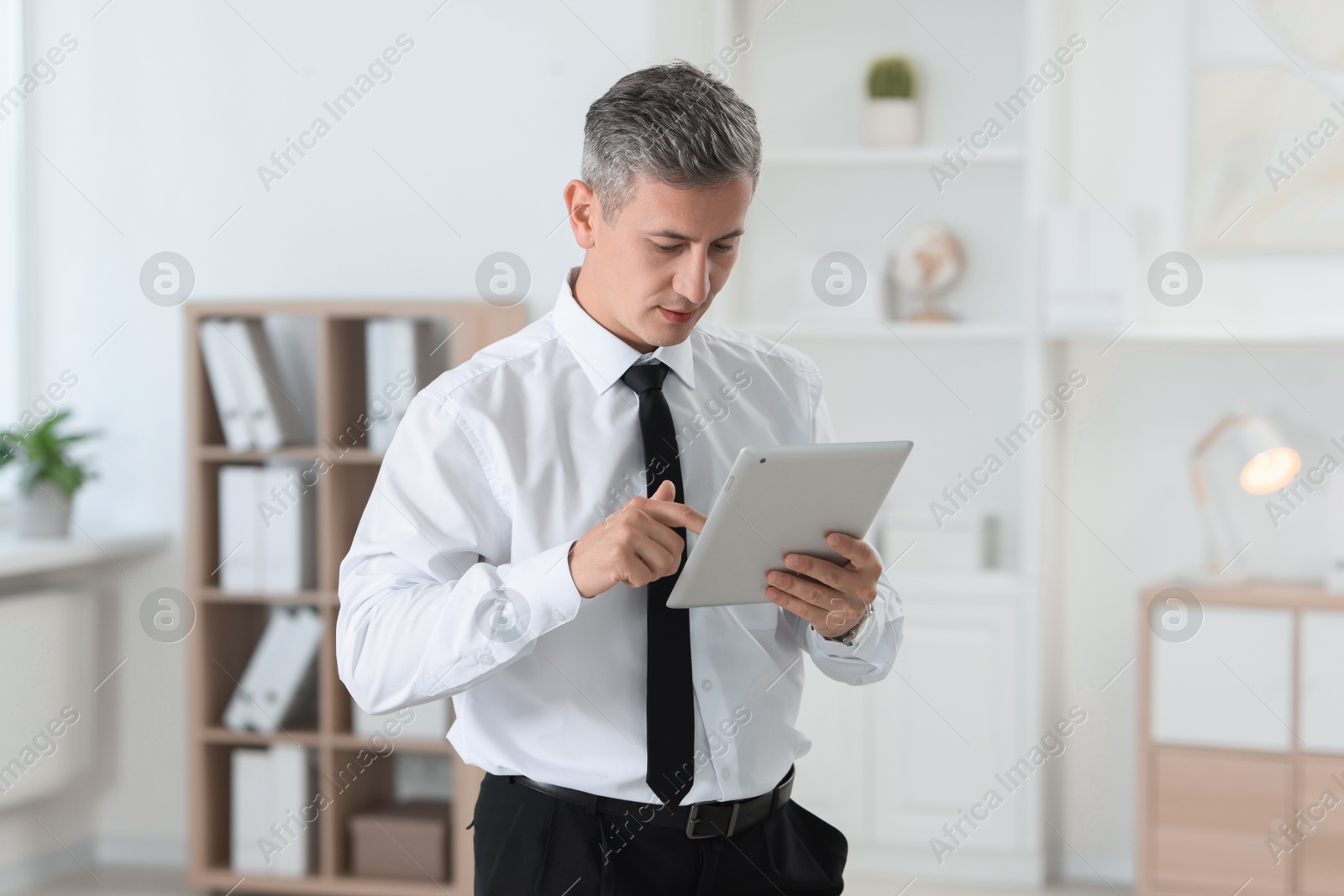 Photo of Portrait of businessman using tablet in office