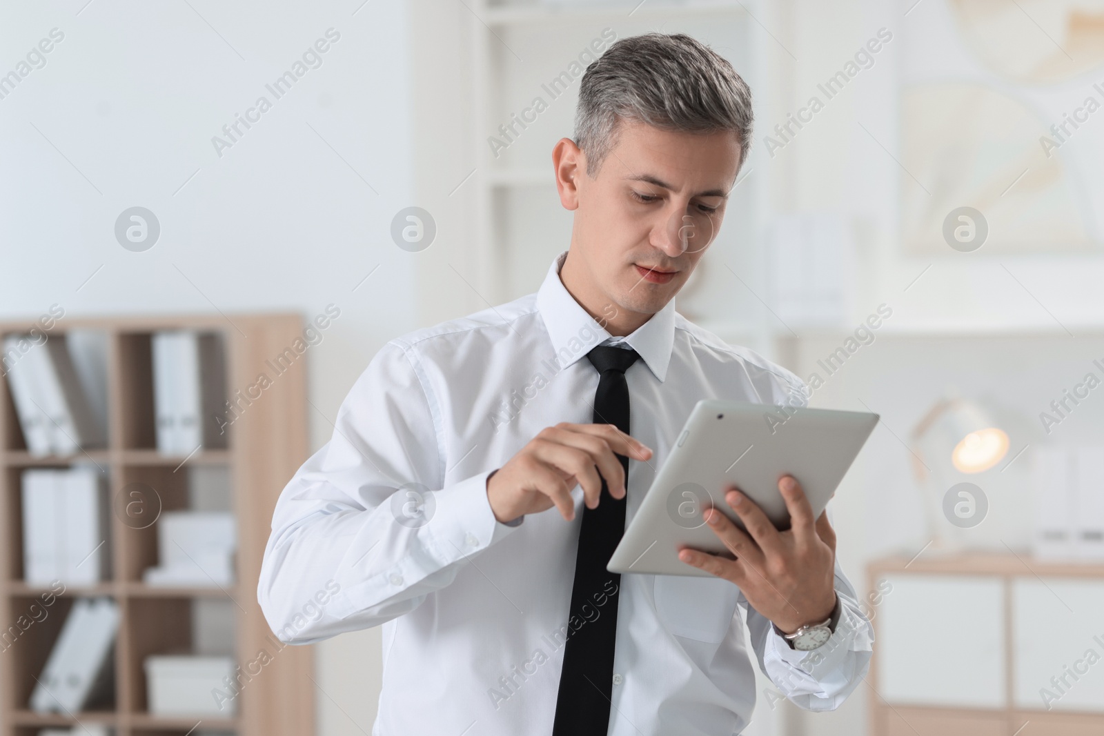 Photo of Portrait of businessman using tablet in office