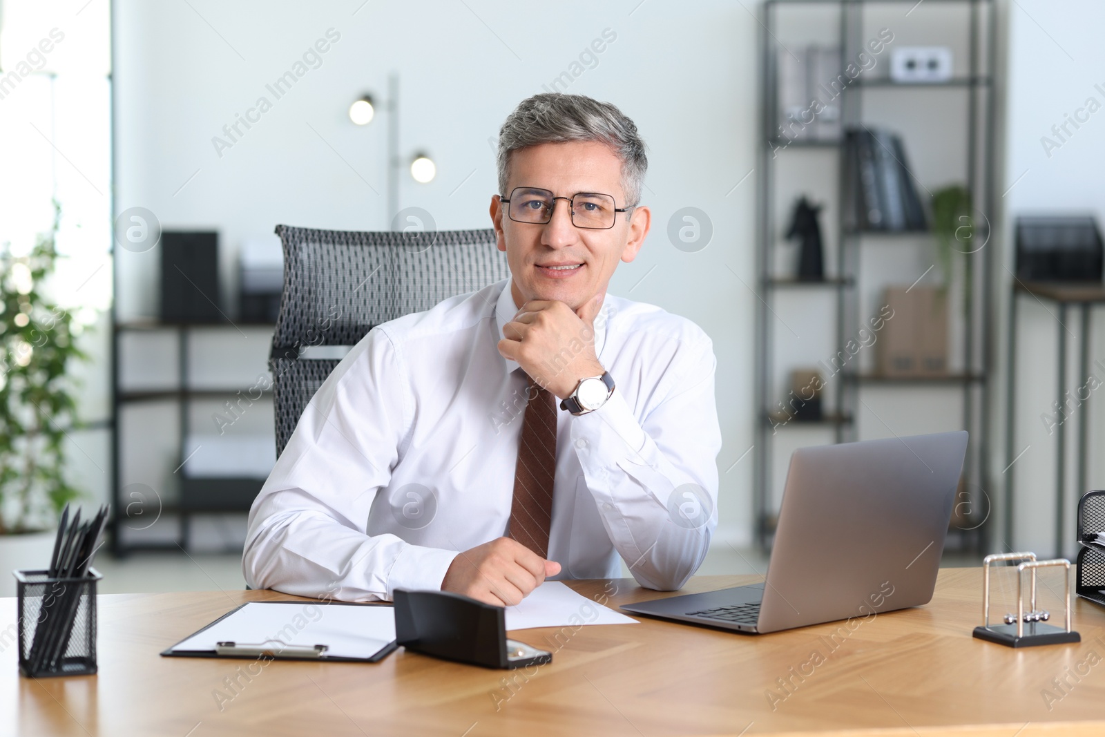 Photo of Portrait of businessman at table in office