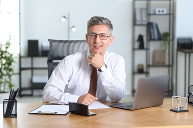 Photo of Portrait of businessman at table in office