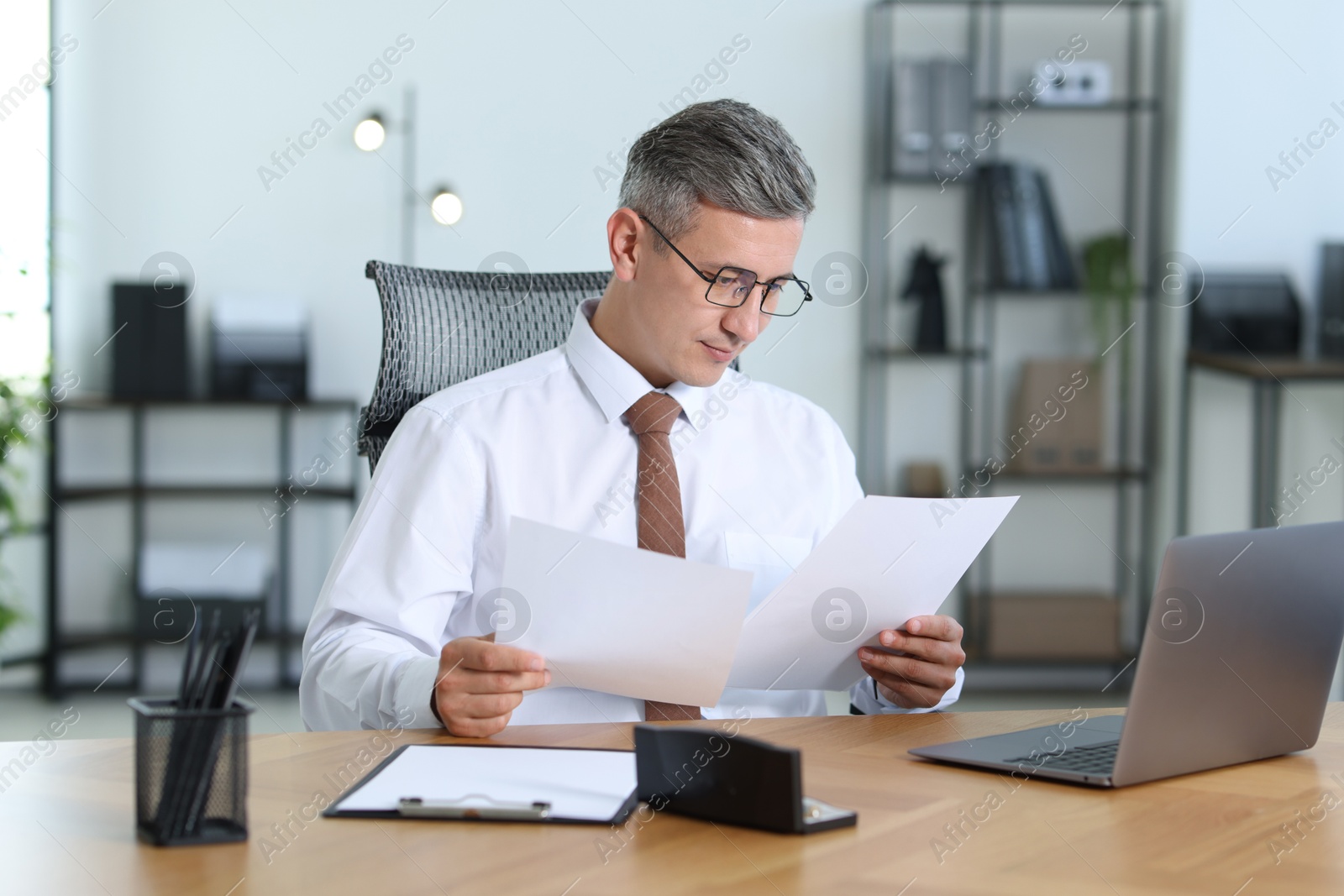 Photo of Businessman working with documents at table in office