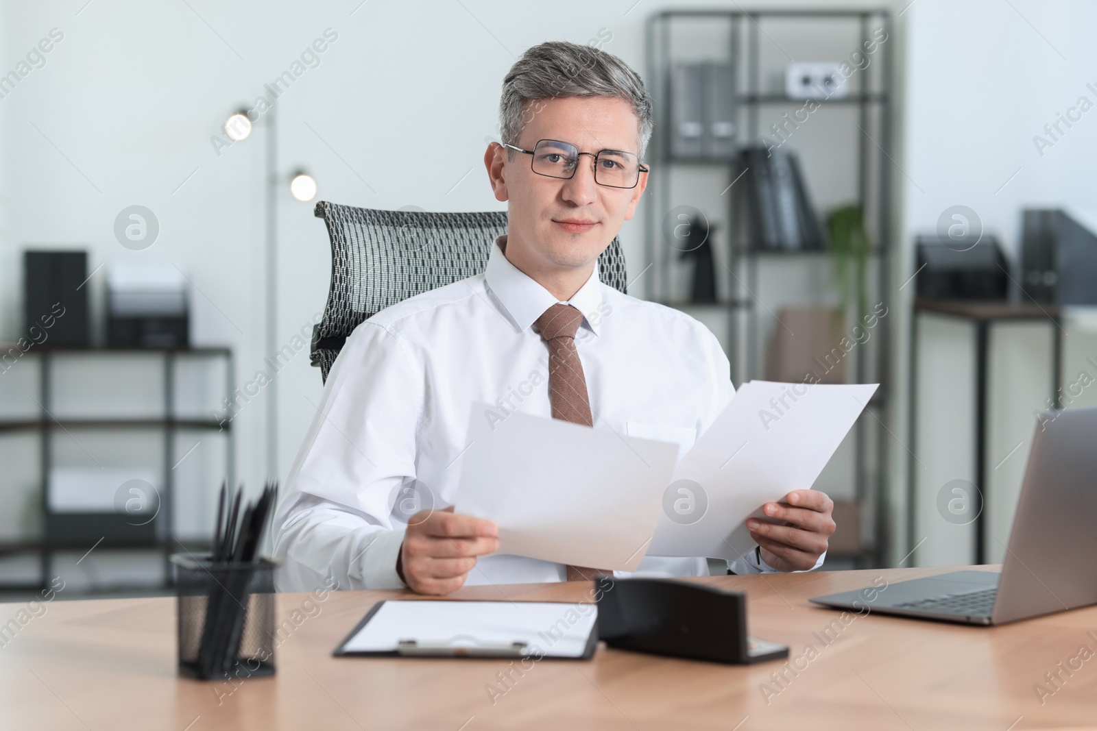 Photo of Businessman working with documents at table in office