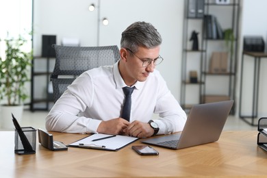 Photo of Portrait of businessman at table in office