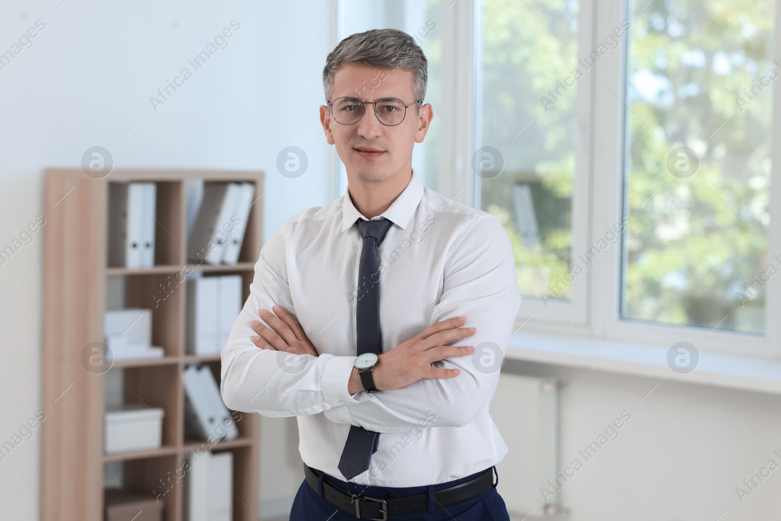 Photo of Portrait of businessman with crossed arms in office